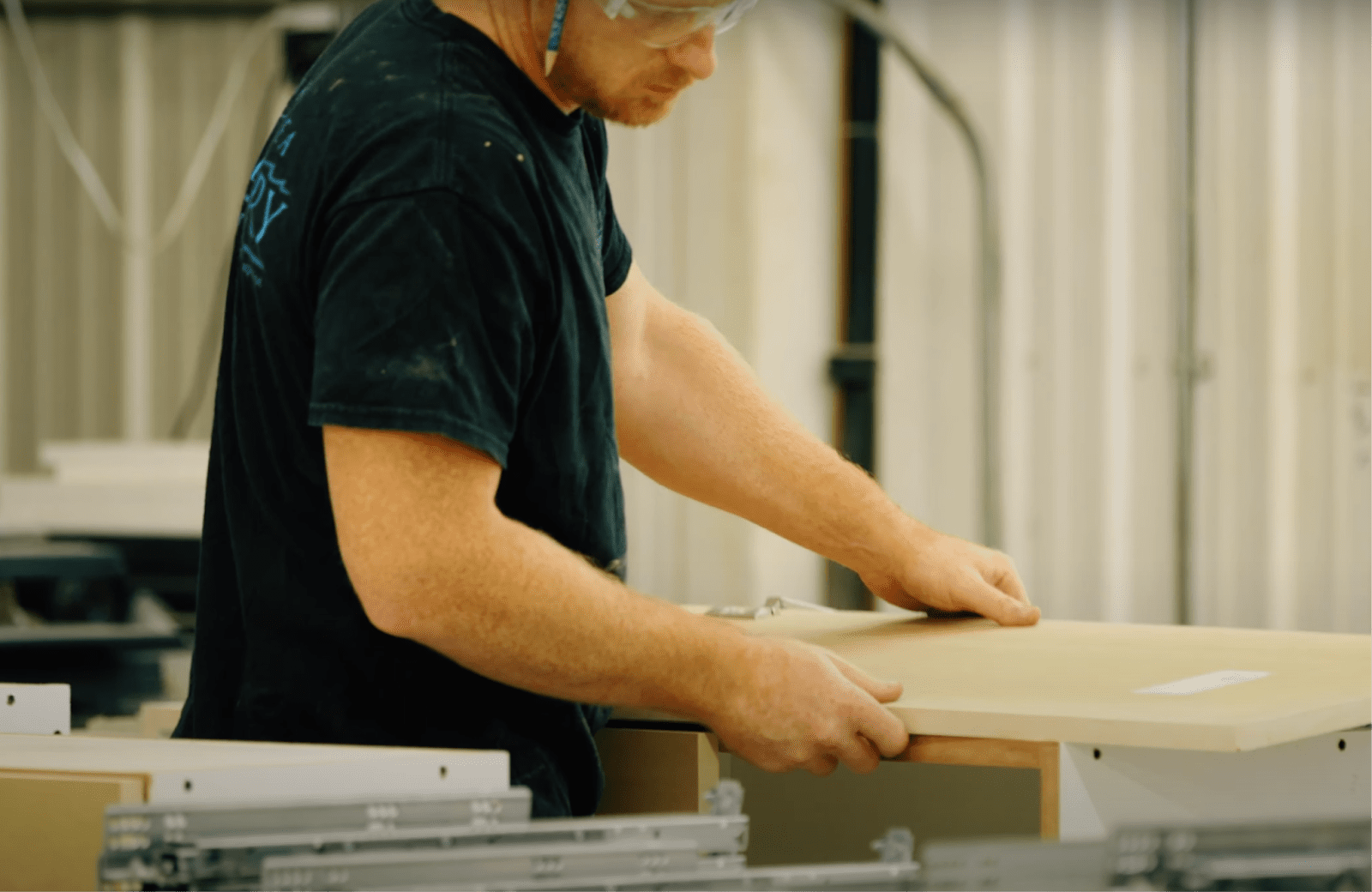 Employee holding wood panel using CNC router